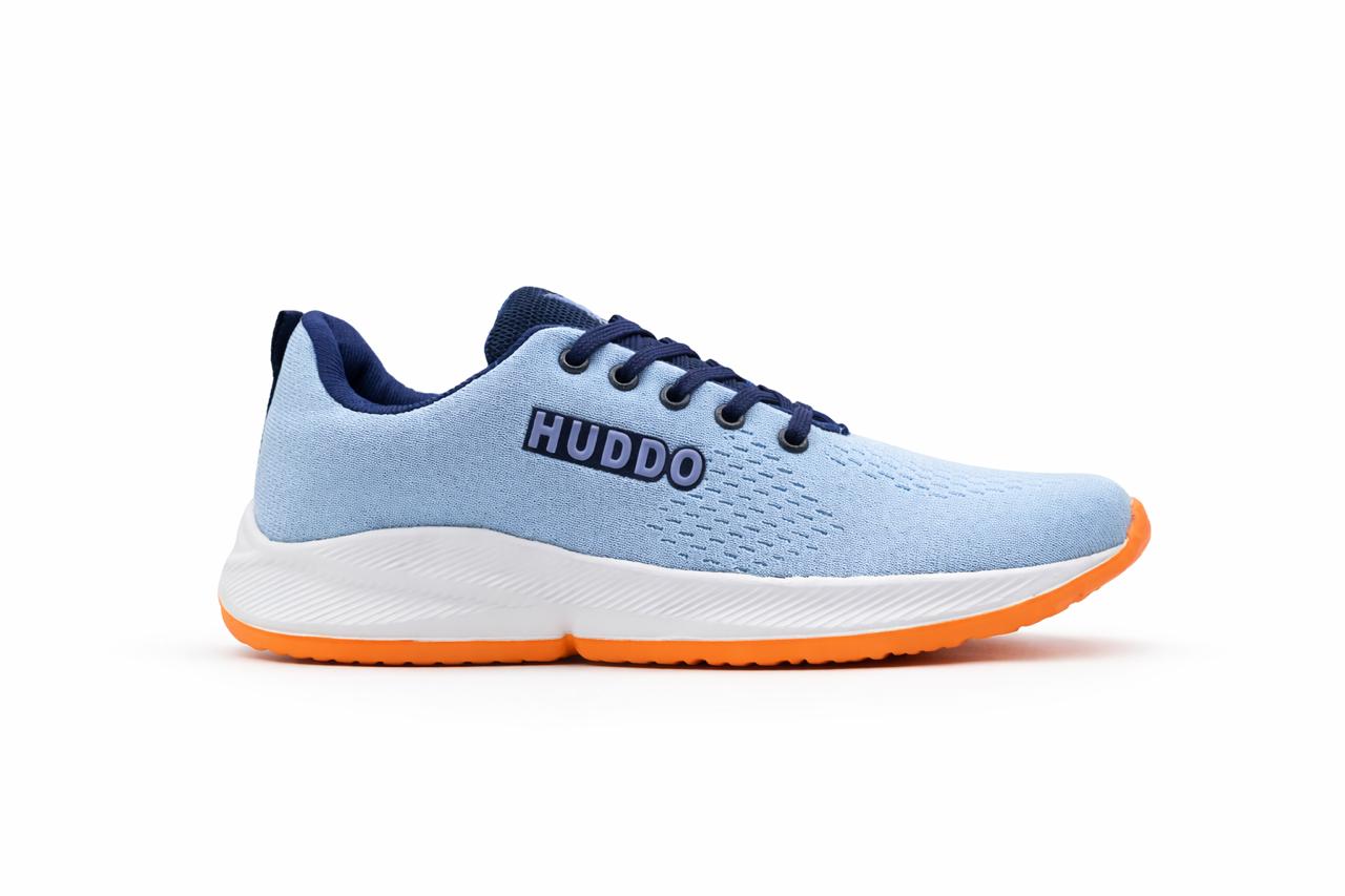 Light blue running shoe with orange sole and navy laces on a white background